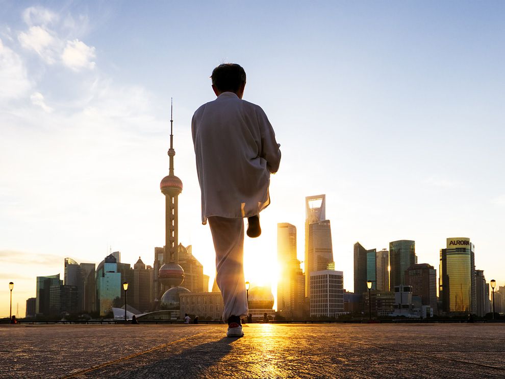 Photo: A man practicing tai chi at sunrise along the Bund in Shanghai